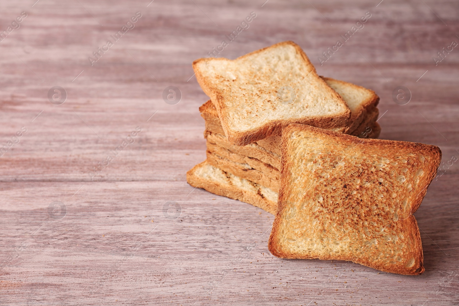 Photo of Tasty toasted bread on wooden background