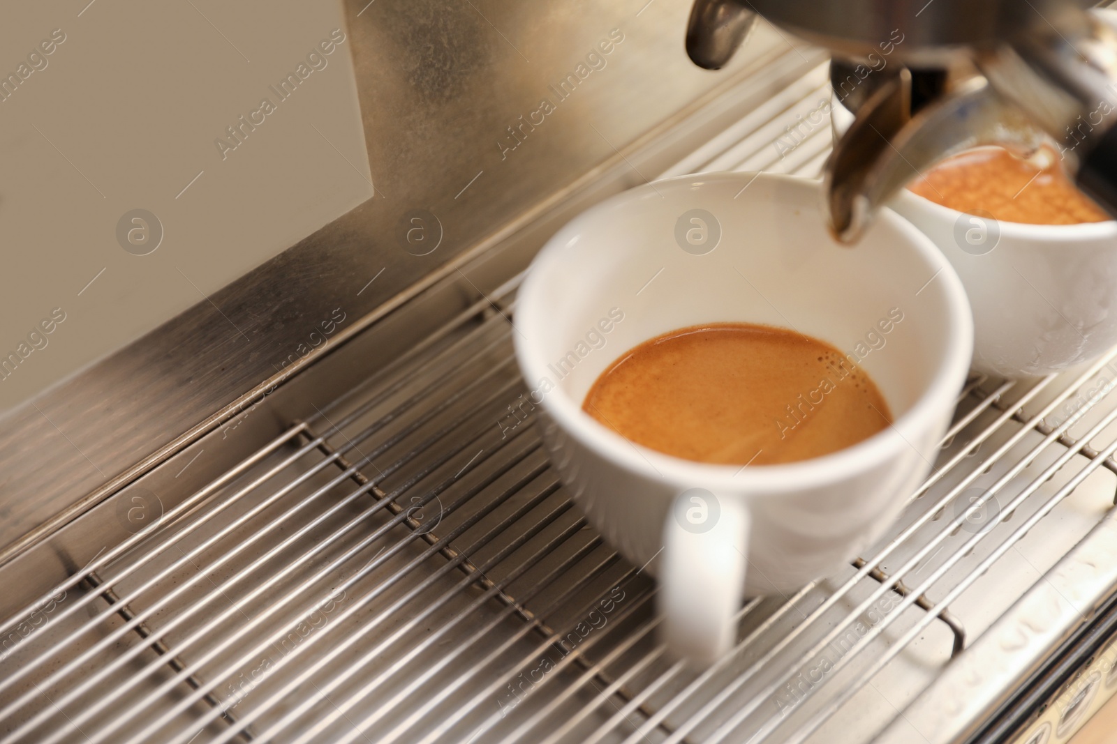 Photo of Coffee machine with cups on drip tray, closeup. Space for text