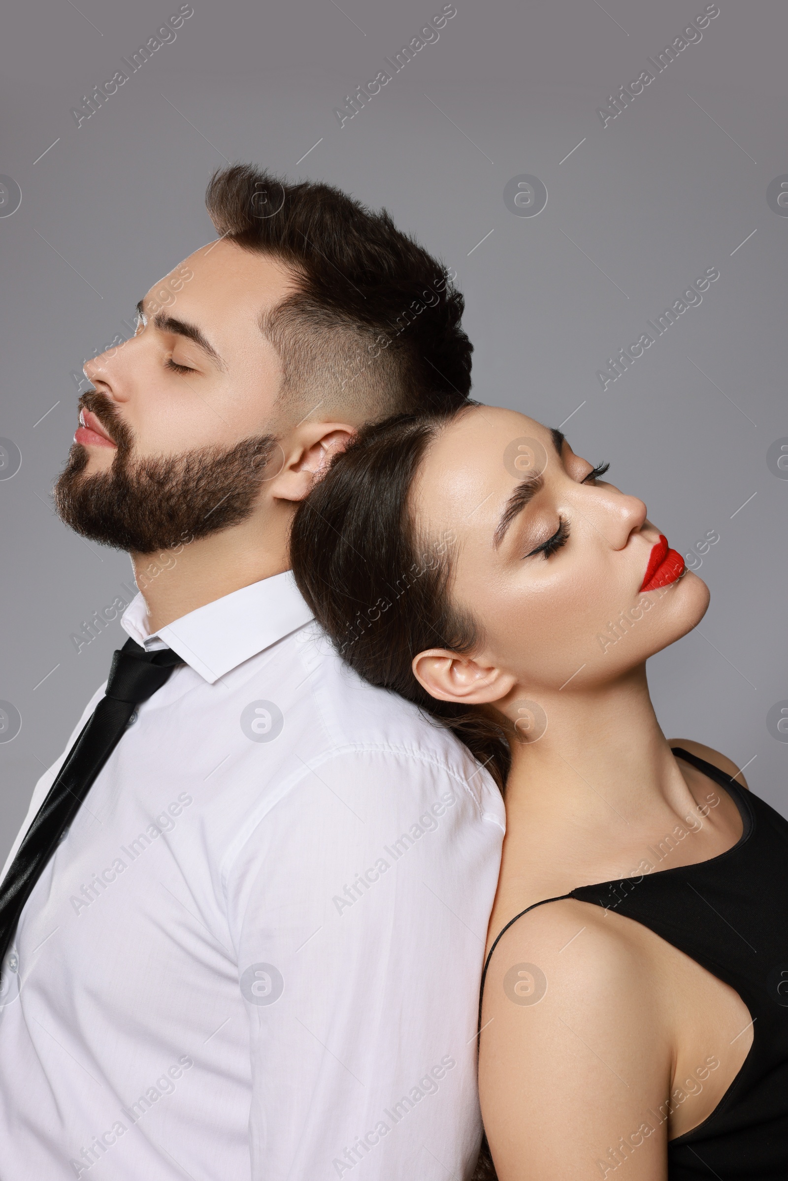 Photo of Handsome bearded man with sexy lady on grey background