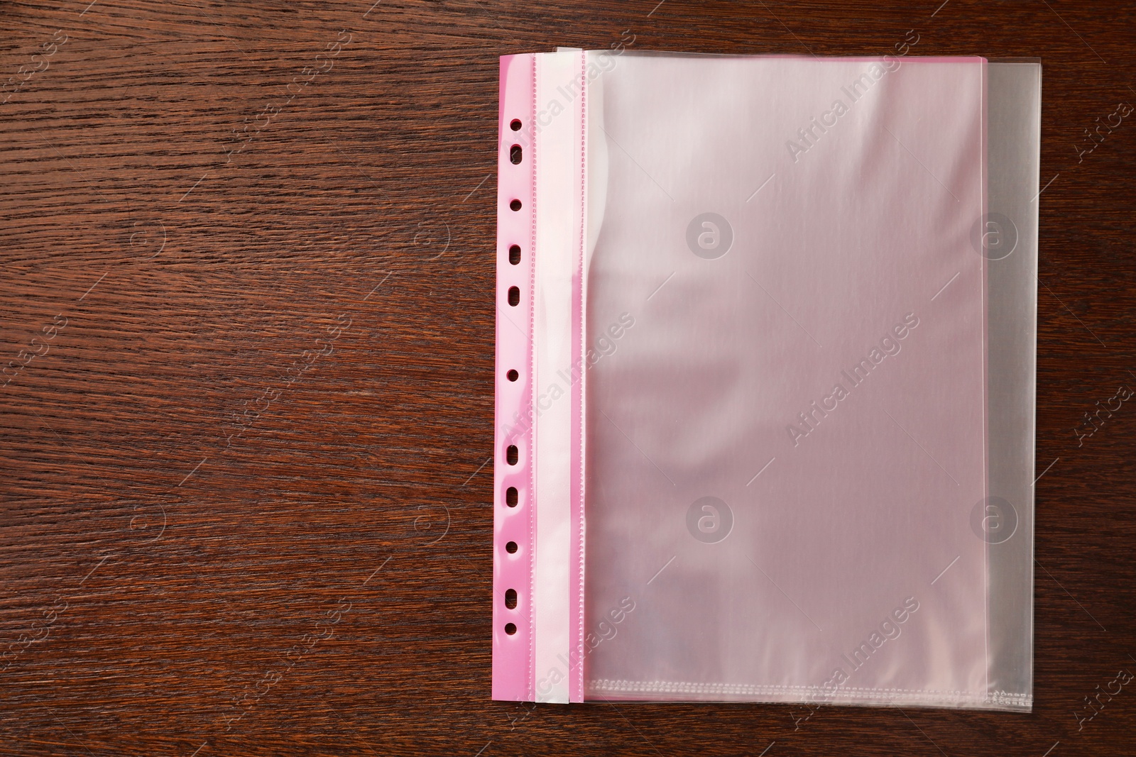 Photo of File folder with punched pockets on wooden table, top view. Space for text