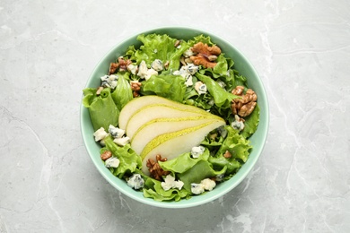 Photo of Tasty salad with pear slices on light grey marble table, top view