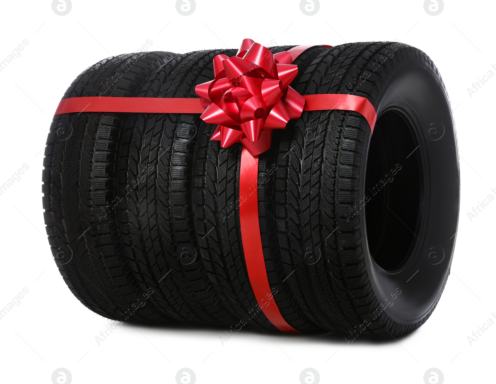 Photo of Winter tires with red ribbon on white background