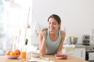 Young woman in fitness clothes having healthy breakfast at home