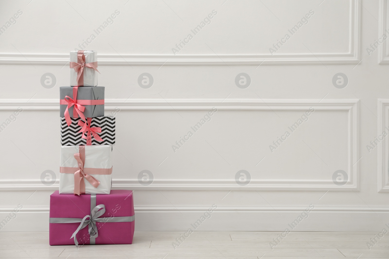 Photo of Many gift boxes near white wall. Space for text