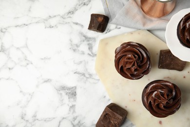 Photo of Flat lay composition with delicious chocolate cupcakes on white marble table. Space for text