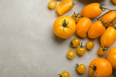 Photo of Ripe yellow tomatoes on grey table, flat lay. Space for text