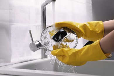 Photo of Woman washing lid in kitchen sink, closeup