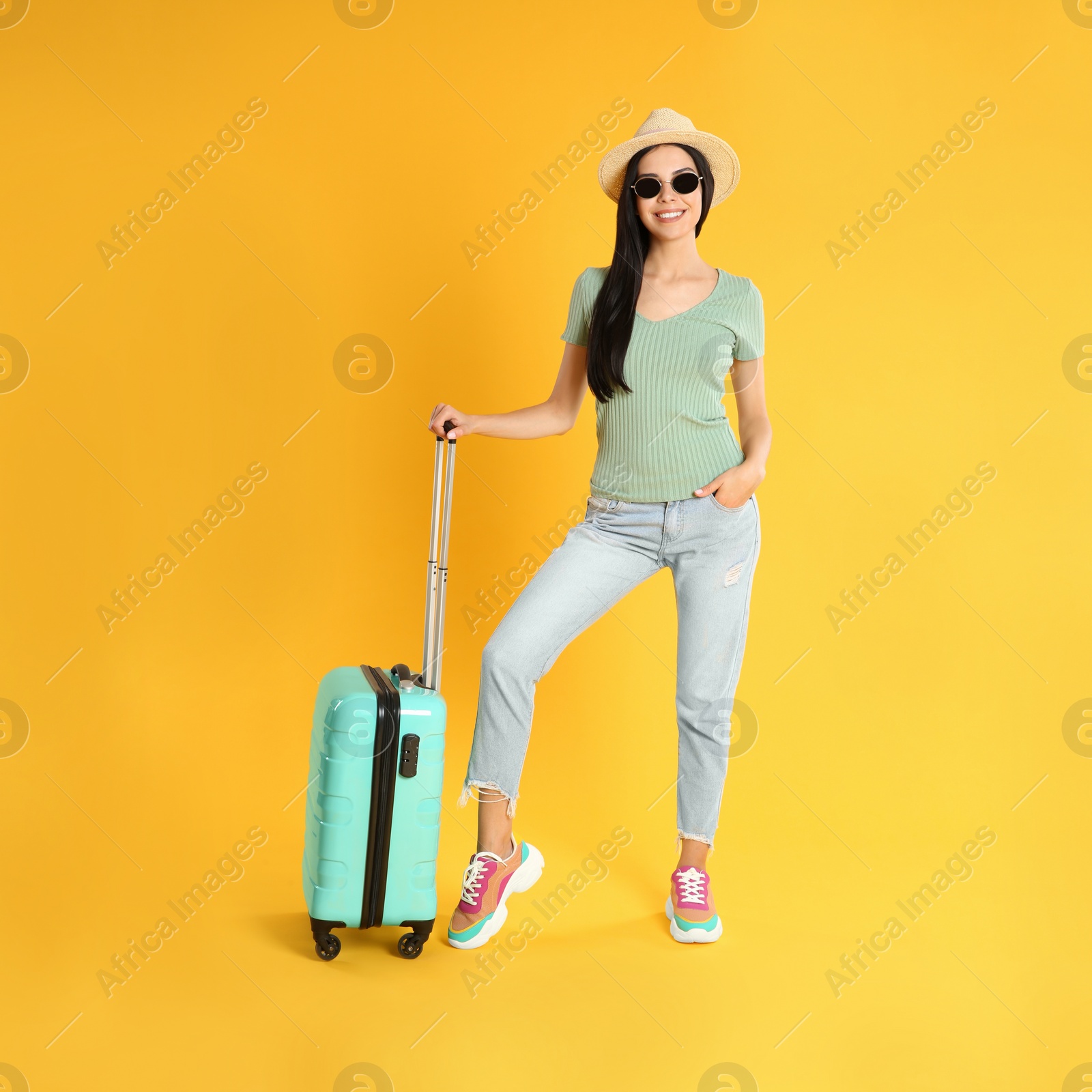 Photo of Beautiful woman with suitcase for summer trip on yellow background. Vacation travel