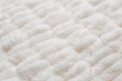 Soft white knitted fabric as background, closeup