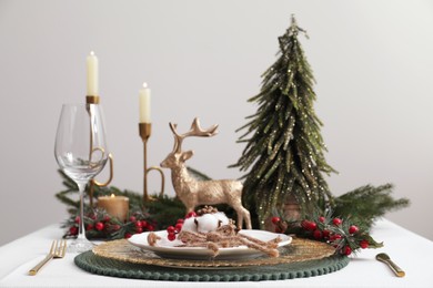 Luxury festive place setting with beautiful decor for Christmas dinner on white table, closeup