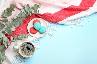 Photo of Flat lay composition with hot drink and warm plaid on light blue background, space for text
