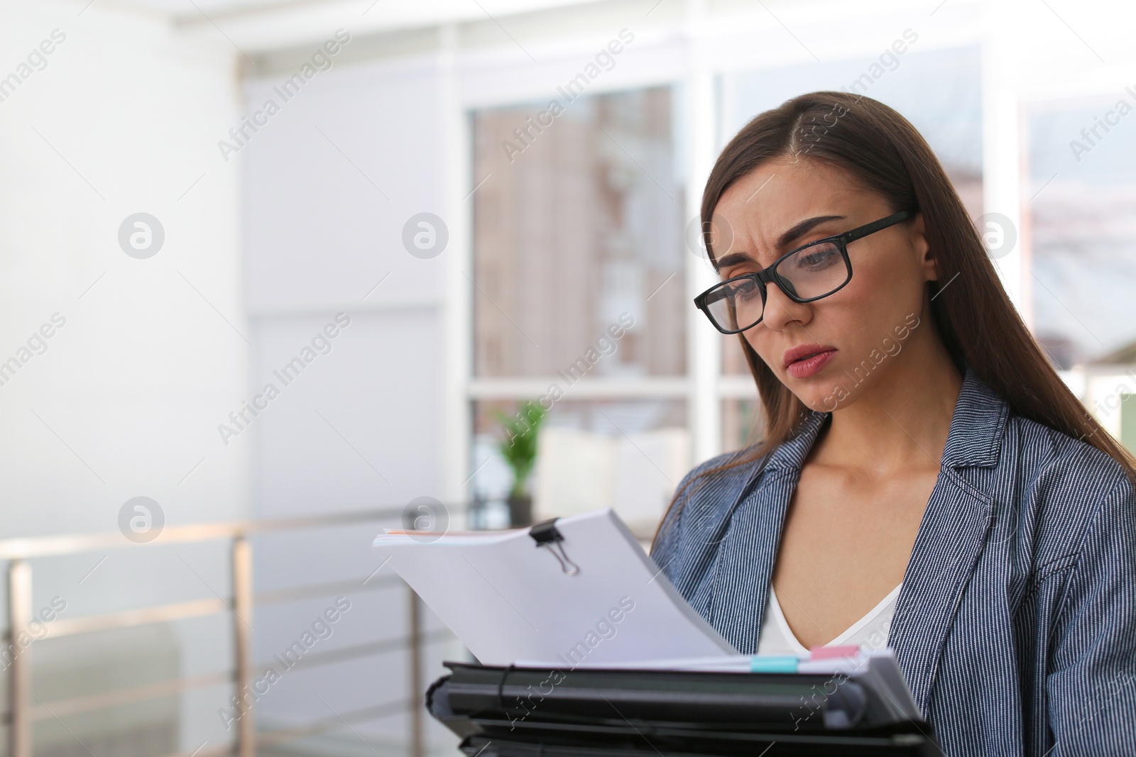 Photo of Young woman working with documents in office. Space for text