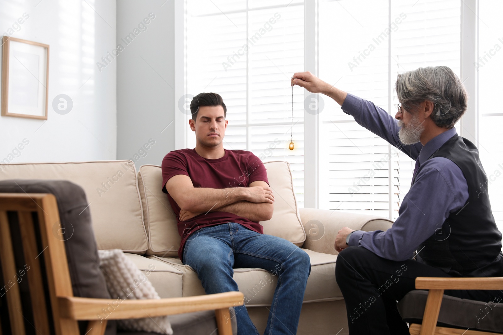 Photo of Psychotherapist using pendulum during hypnotherapy   session in office