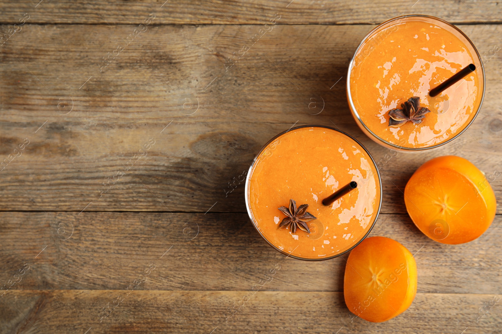 Photo of Tasty persimmon smoothie with anise and fresh fruits on wooden table, flat lay. Space for text