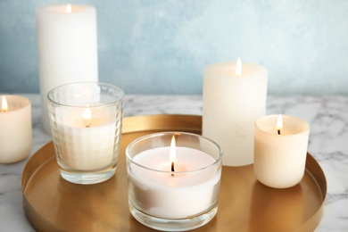 Tray with burning aromatic candles on table