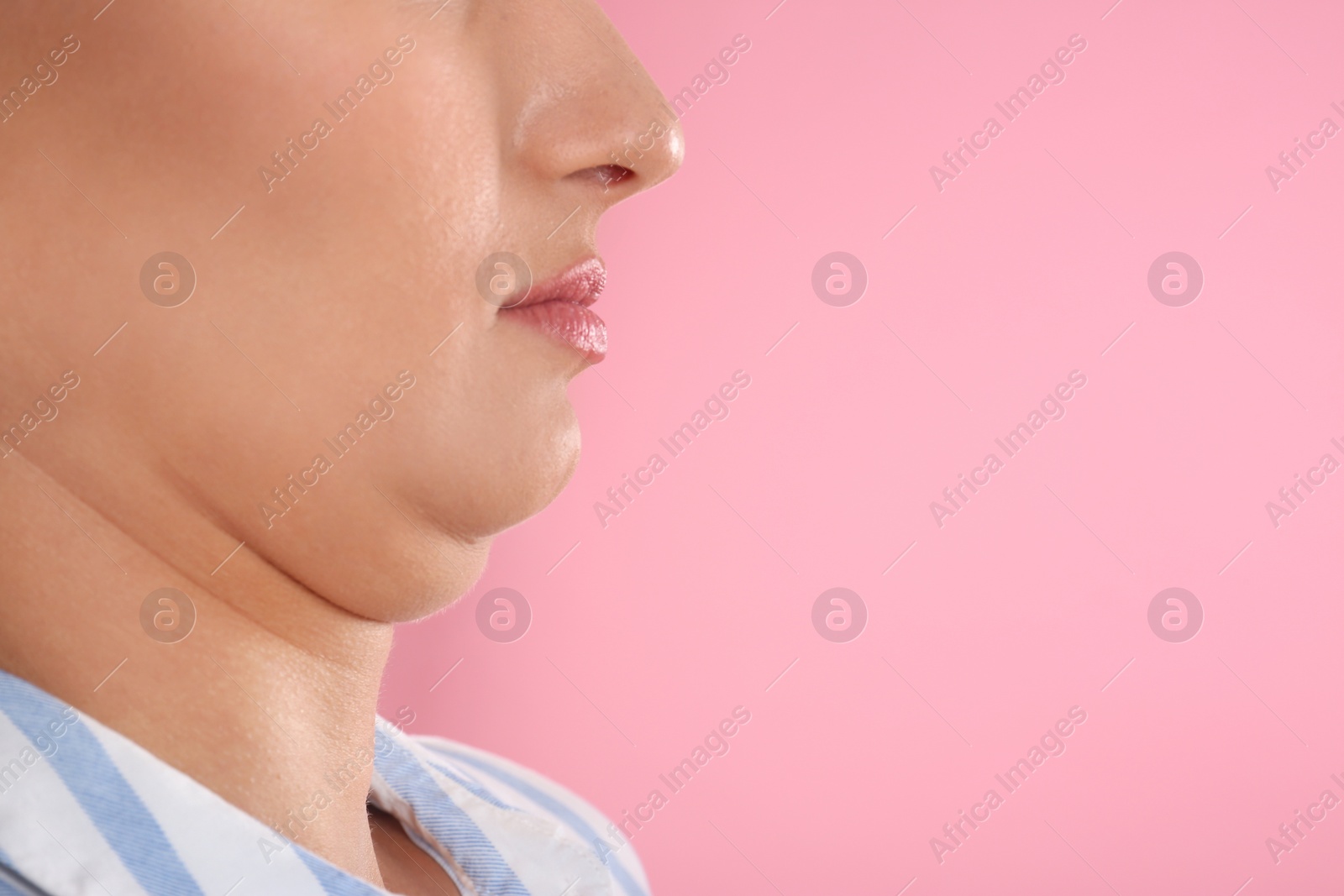 Photo of Young woman with double chin on pink background, closeup. Space for text