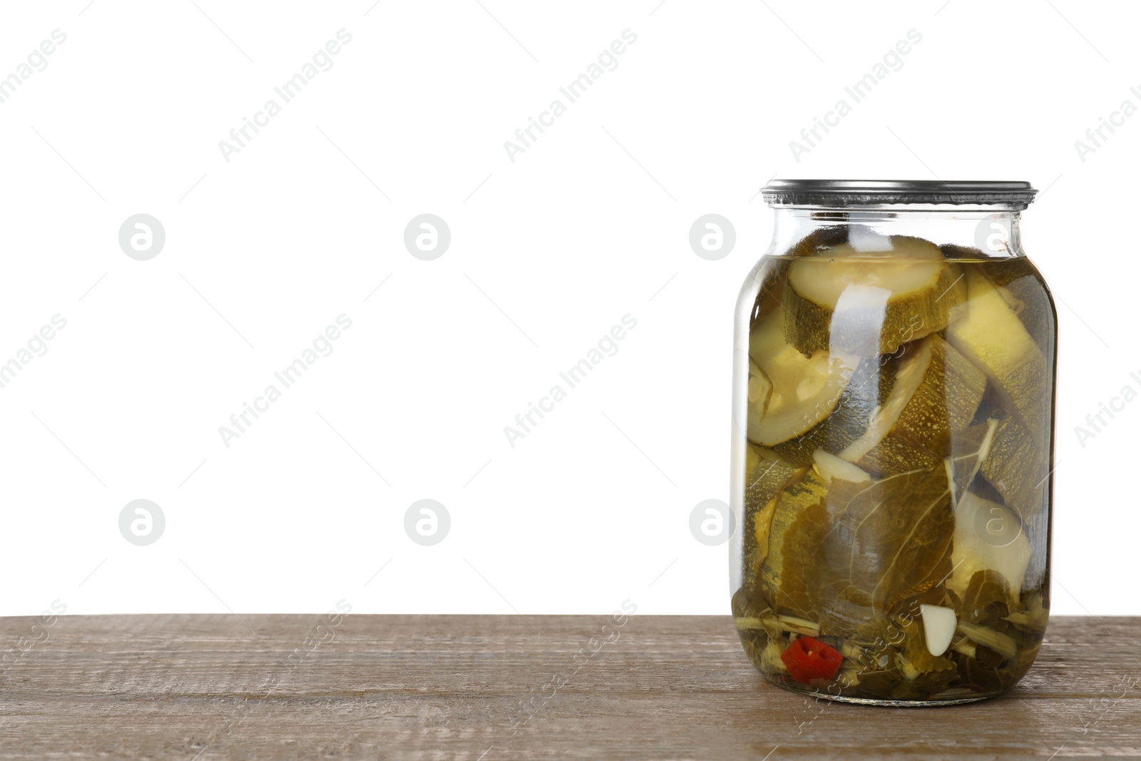 Photo of Jar of pickled sliced zucchini on wooden table against white background. Space for text