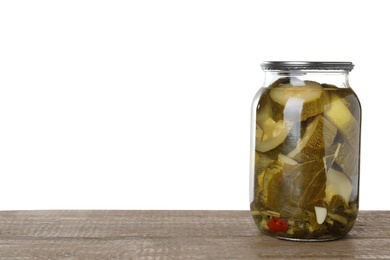 Photo of Jar of pickled sliced zucchini on wooden table against white background. Space for text