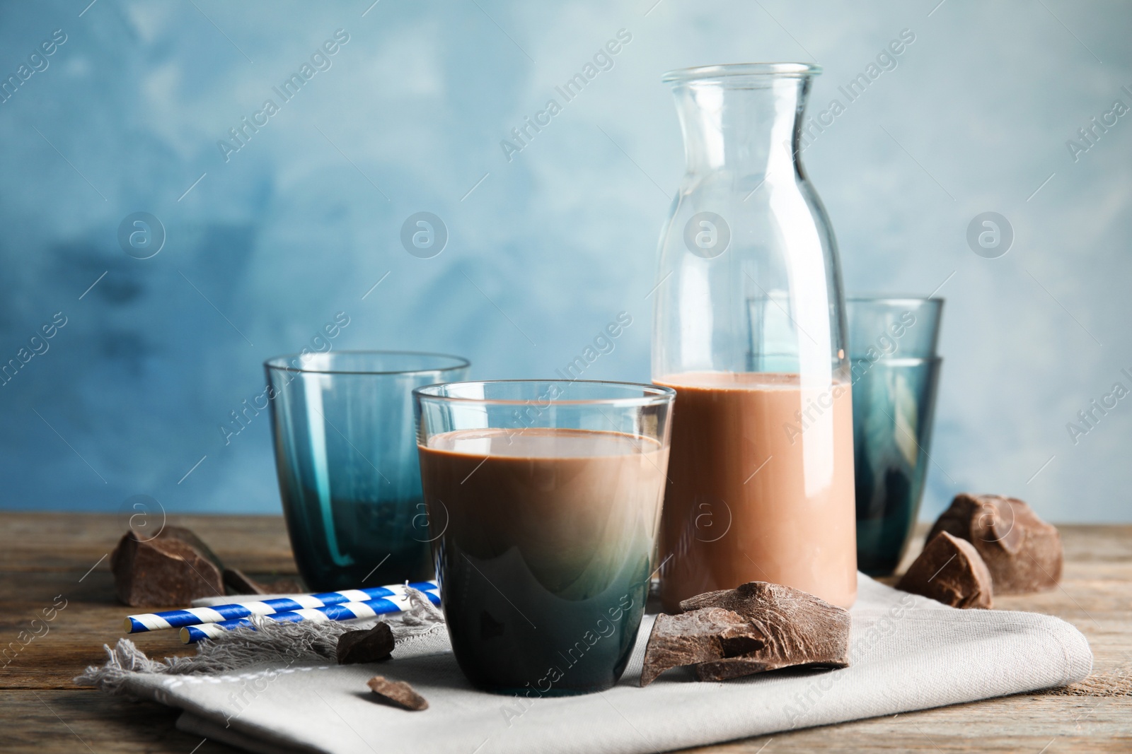 Photo of Glass of tasty chocolate milk on wooden table. Dairy drink