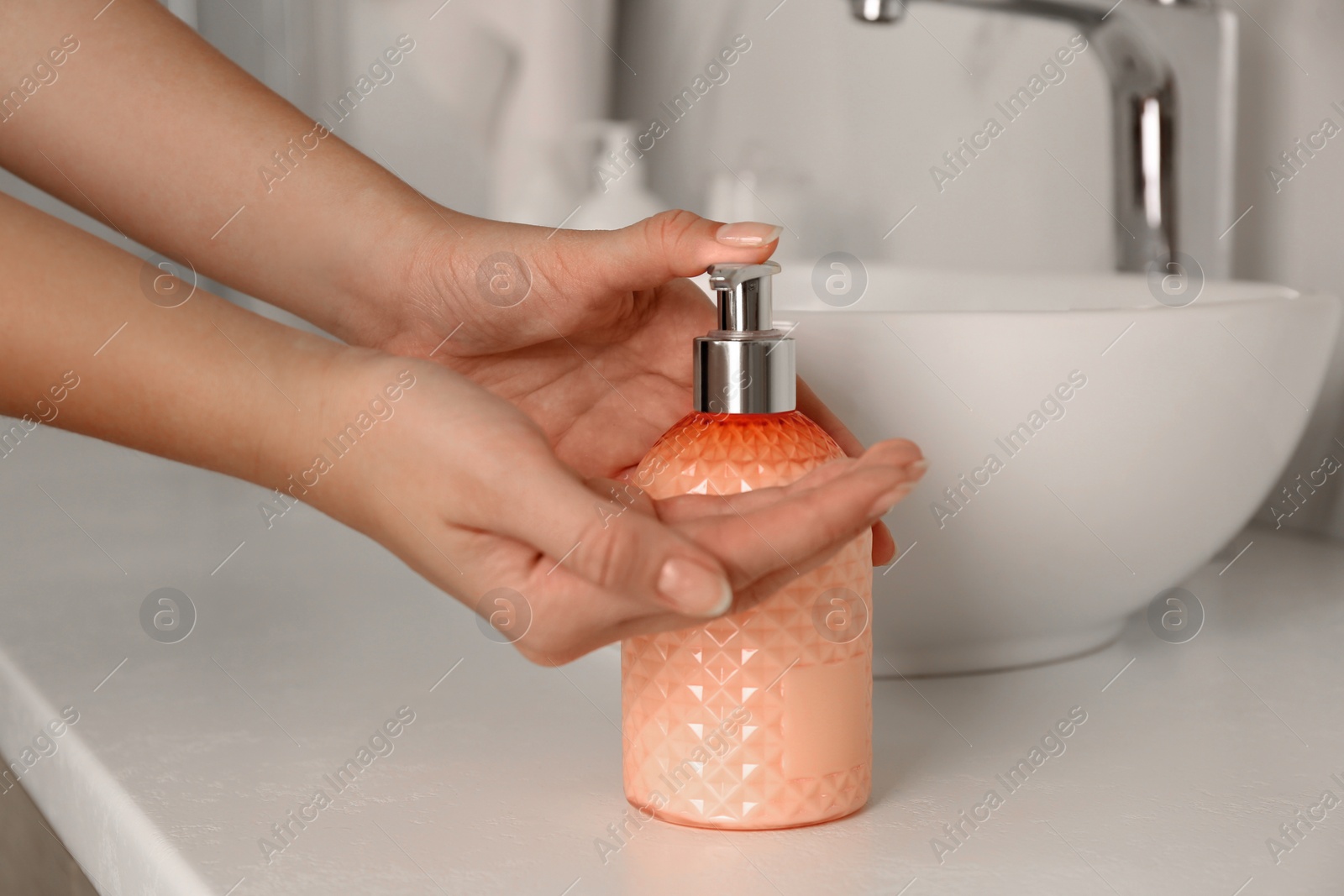 Photo of Woman using liquid soap in bathroom, closeup