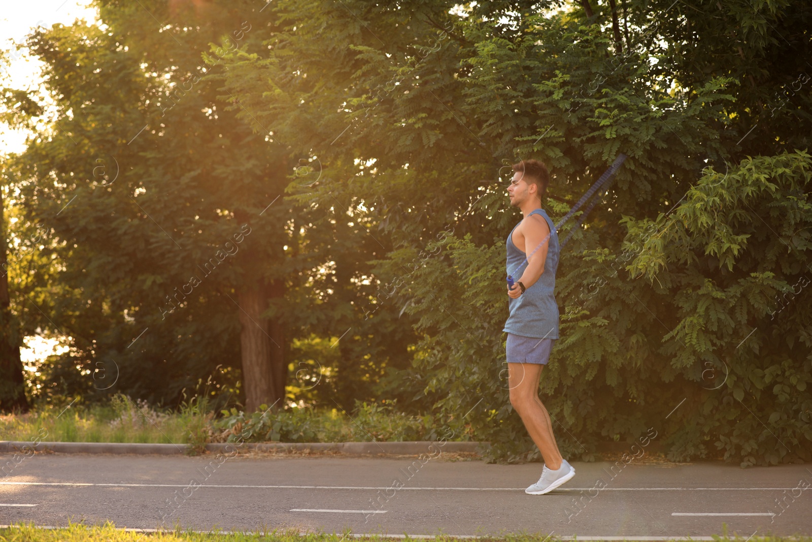 Photo of Young man training with jump rope in park