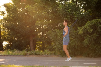 Young man training with jump rope in park