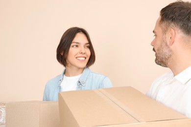 Happy couple with moving boxes in new apartment