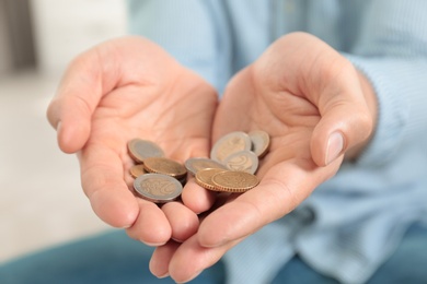 Photo of Man holding coins in hands indoors, closeup