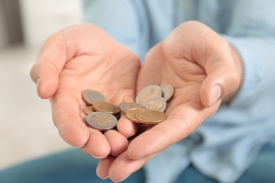 Man holding coins in hands indoors, closeup