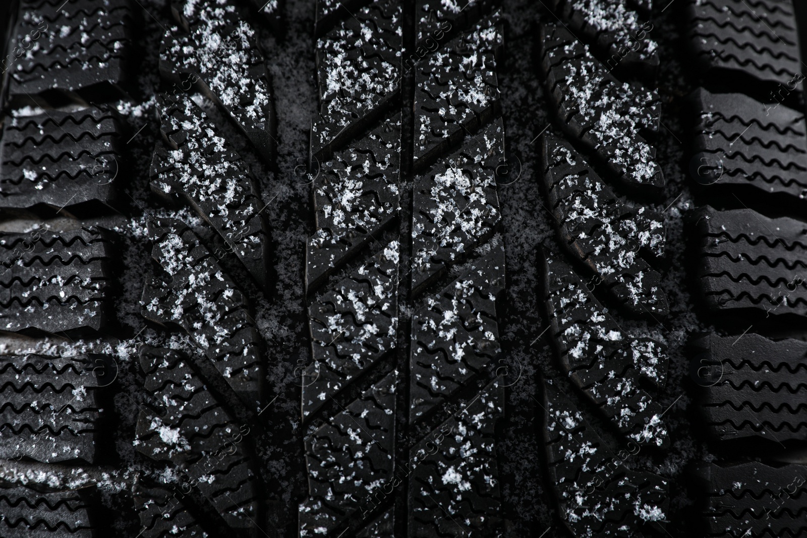 Photo of Snowy winter tire as background, closeup. Car maintenance