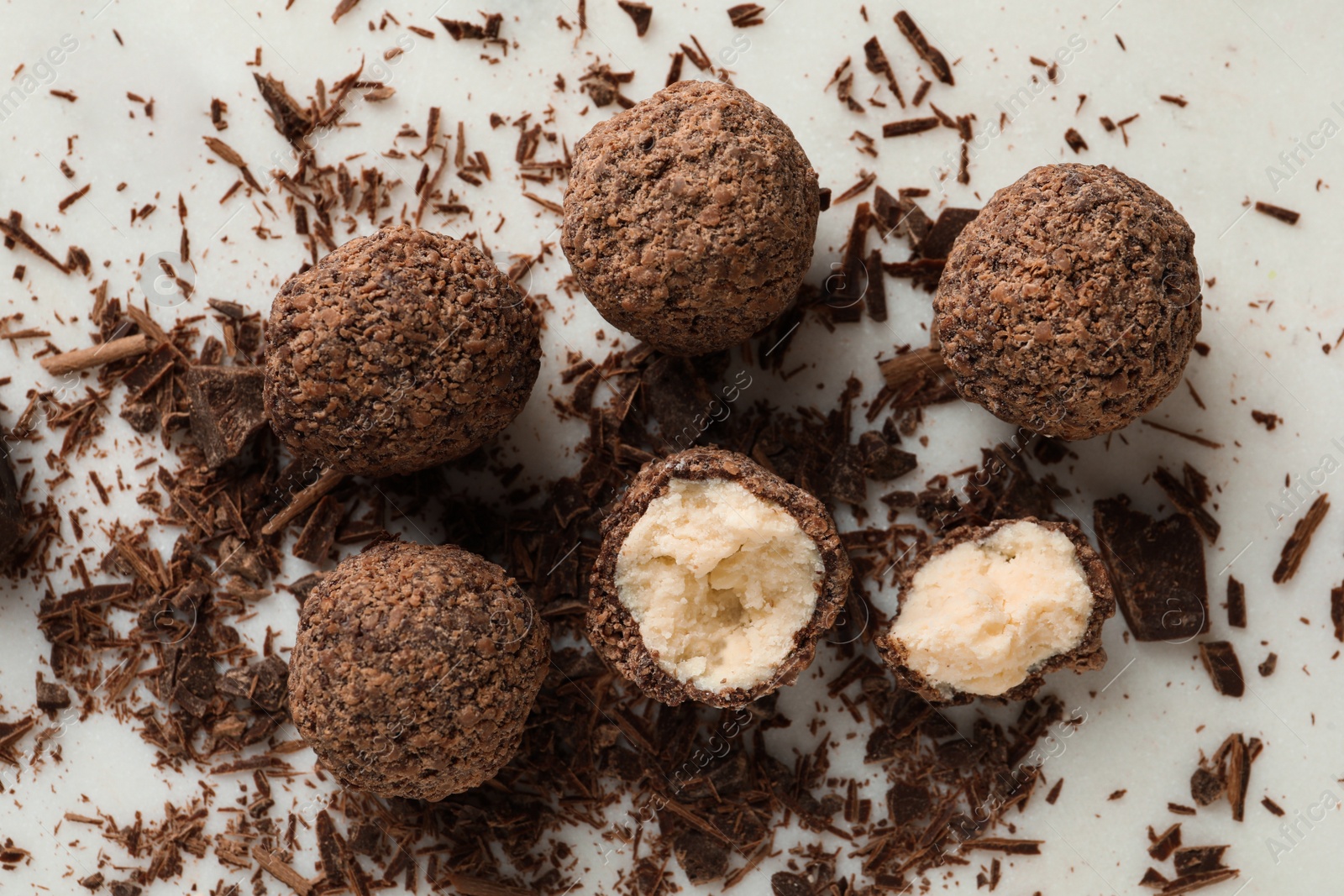 Photo of Many delicious chocolate truffles on white table, flat lay