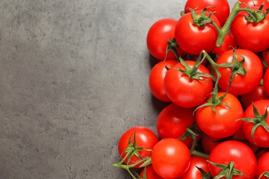 Photo of Heap of fresh cherry tomatoes on stone background, top view. Space for text