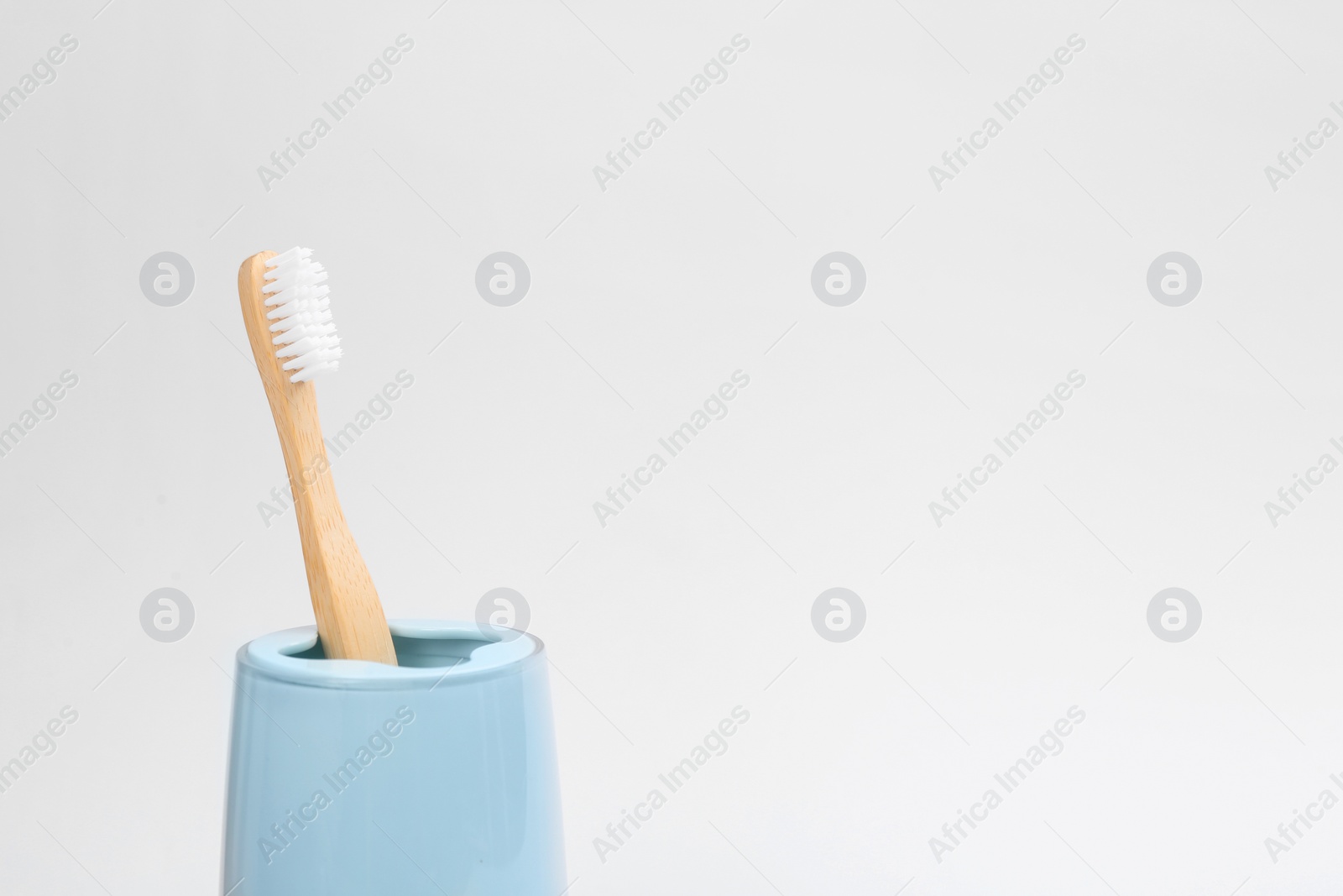 Photo of Bamboo toothbrush in holder isolated on white