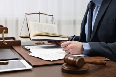 Photo of Lawyer working with documents at wooden table indoors, closeup