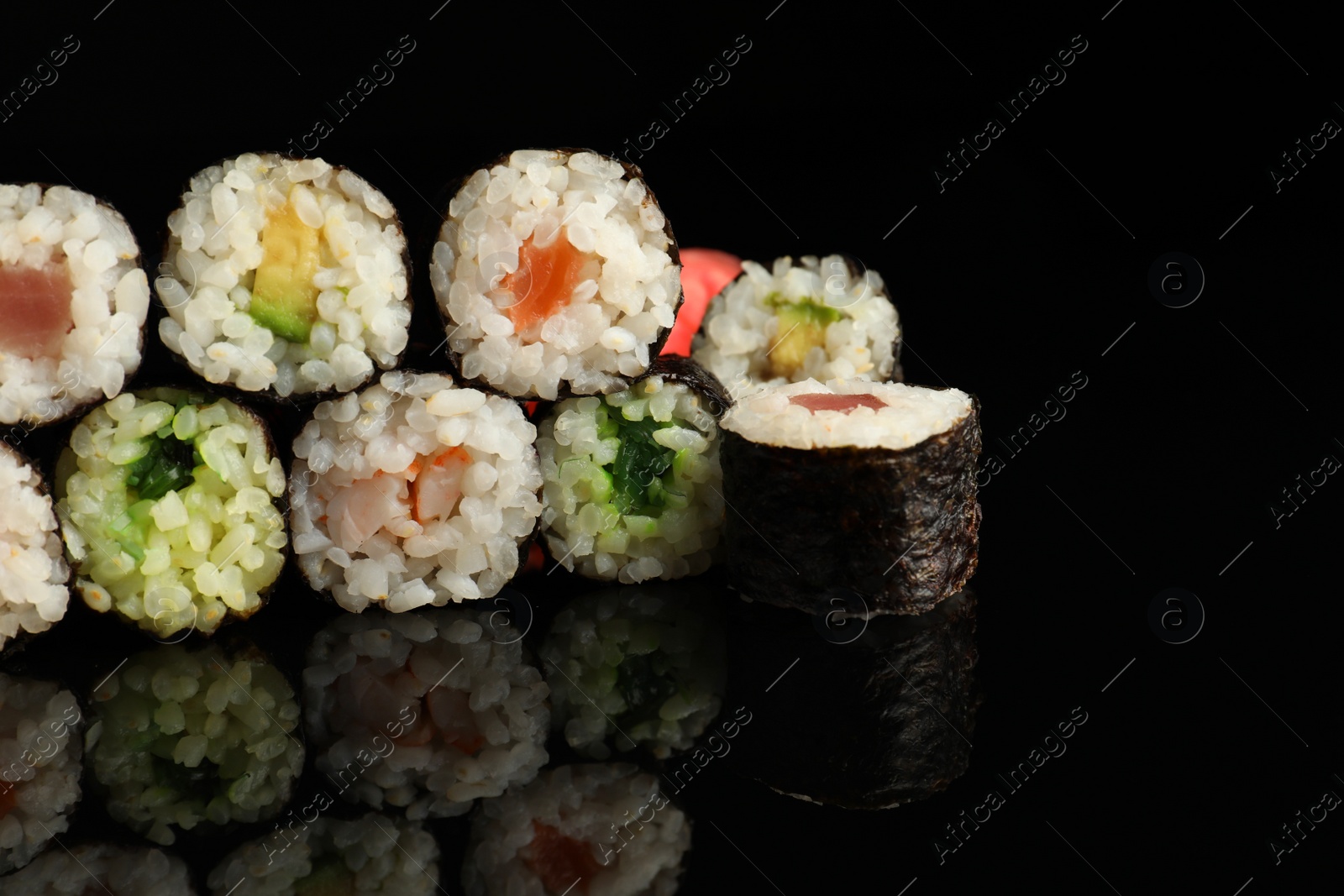 Photo of Set of delicious sushi rolls on black background, closeup