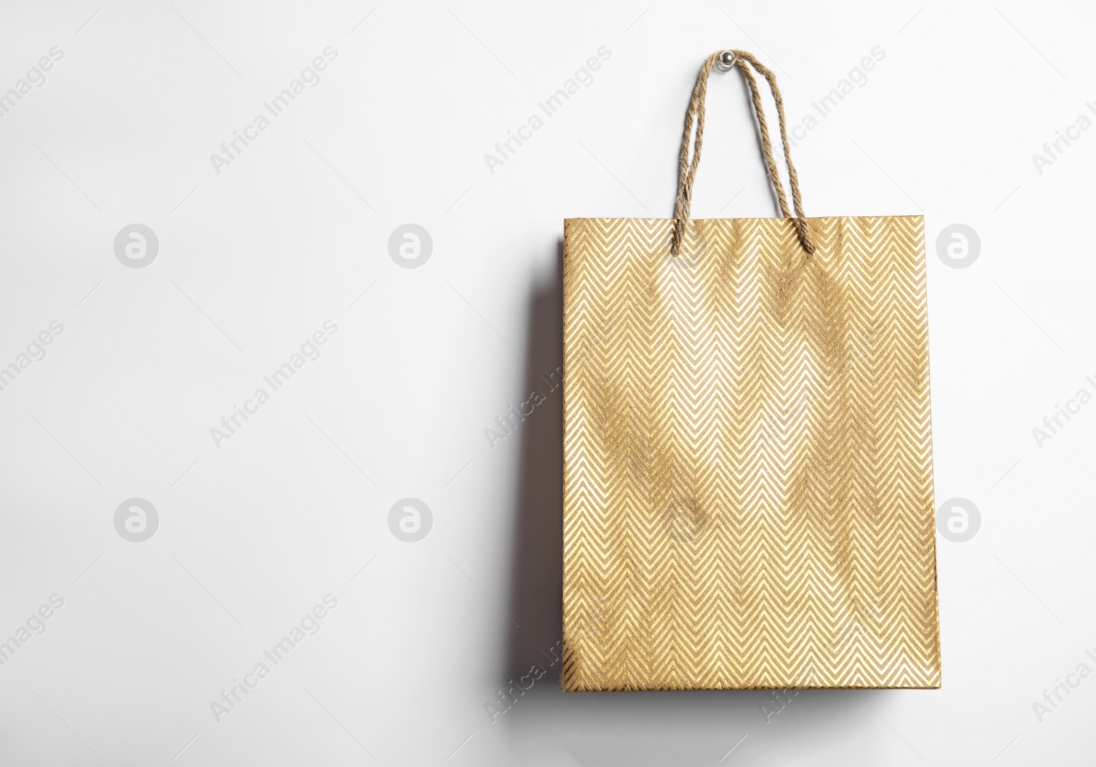 Photo of Gold shopping paper bag isolated on white