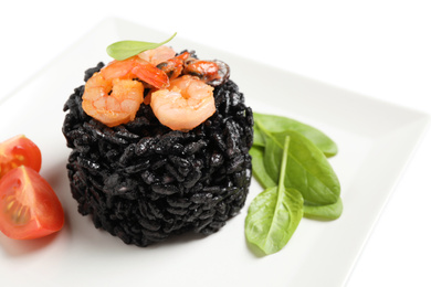 Delicious black risotto with seafood on white background, closeup