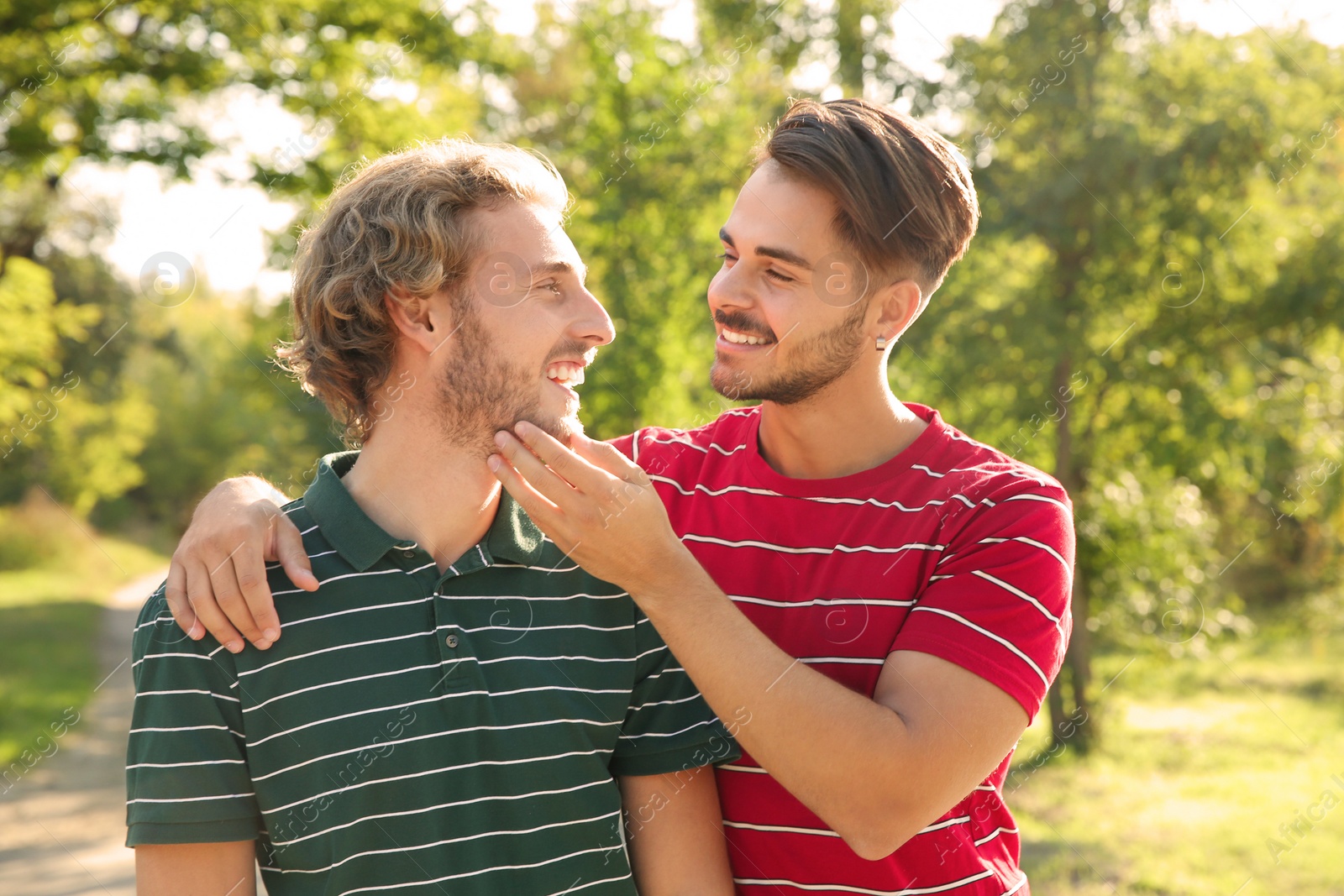 Photo of Portrait of happy gay couple smiling in park