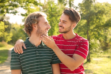 Photo of Portrait of happy gay couple smiling in park