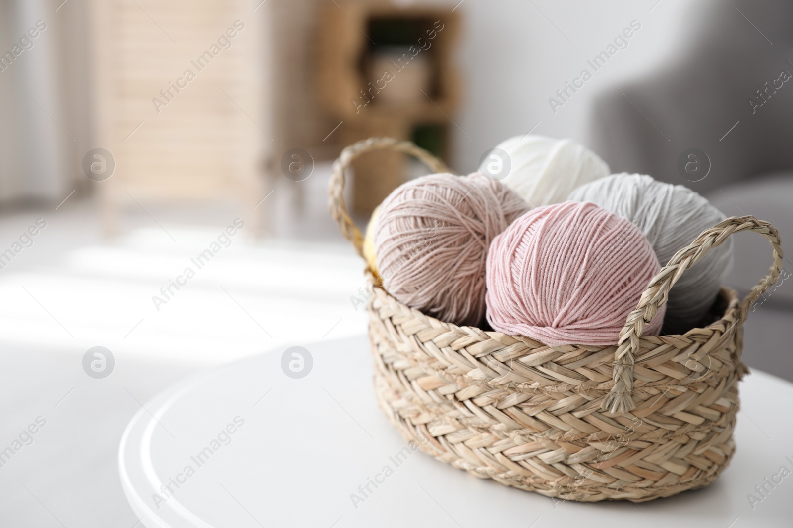 Photo of Wicker basket with clews on table indoors, space for text. Engaging in hobby