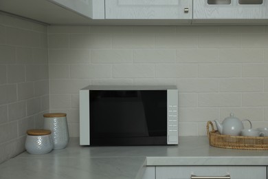 Photo of Modern microwave oven on countertop in kitchen