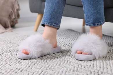 Photo of Woman in fluffy slippers at home, closeup
