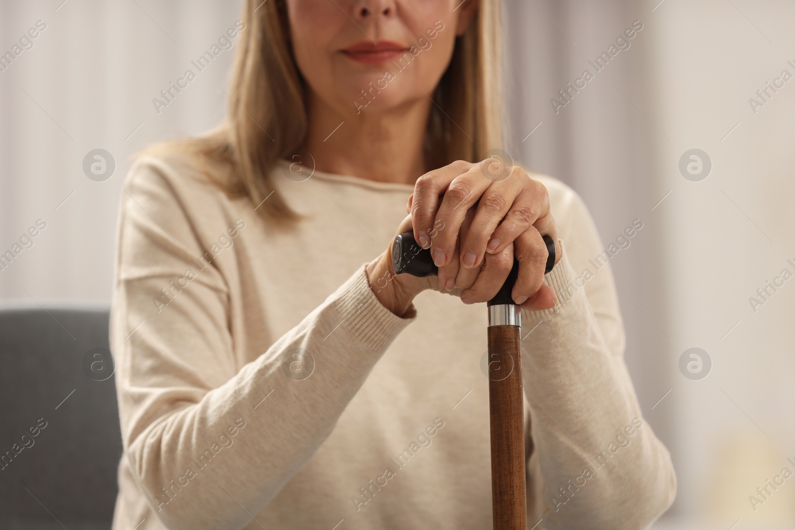 Photo of Mature woman with walking cane indoors, closeup
