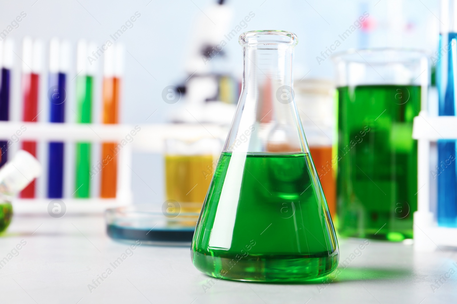 Photo of Conical flask and other glassware on table in chemistry laboratory. Space for text