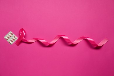 Pink ribbon on color background, flat lay. Breast cancer awareness