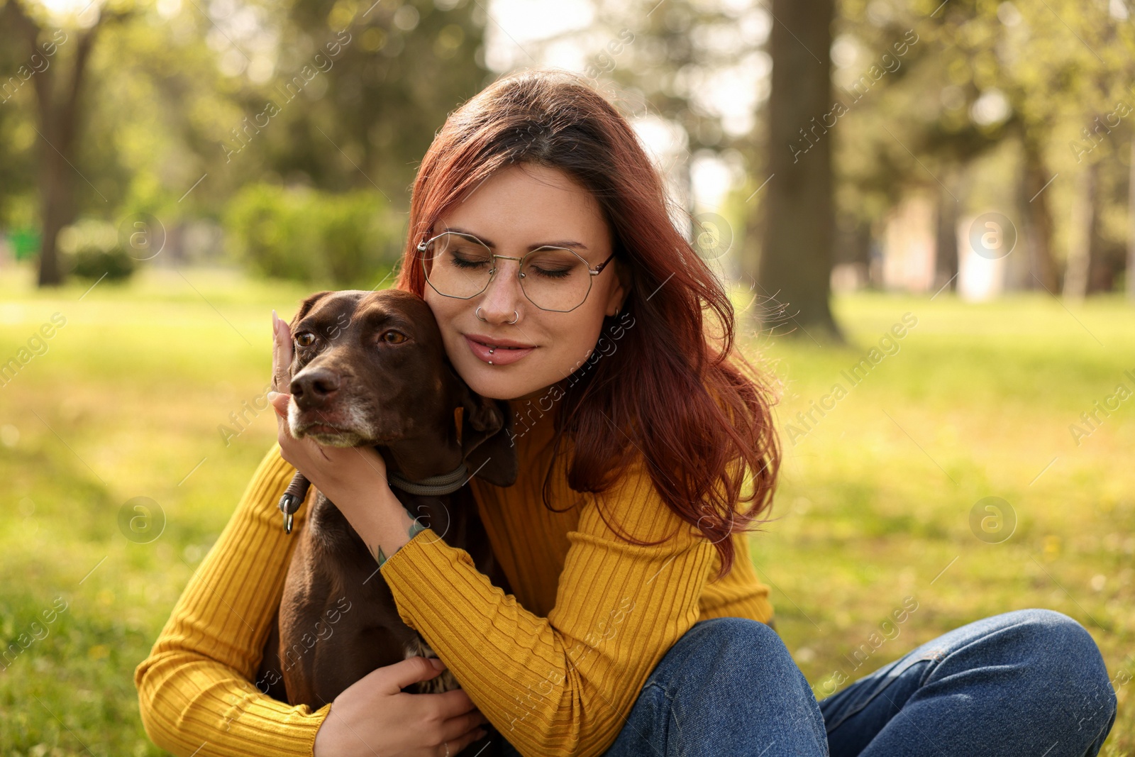 Photo of Woman with her cute German Shorthaired Pointer dog in park on spring day