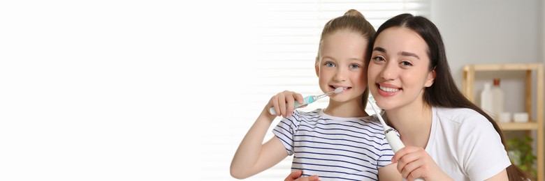 Mother and her daughter brushing teeth together in bathroom. Banner design with space for text