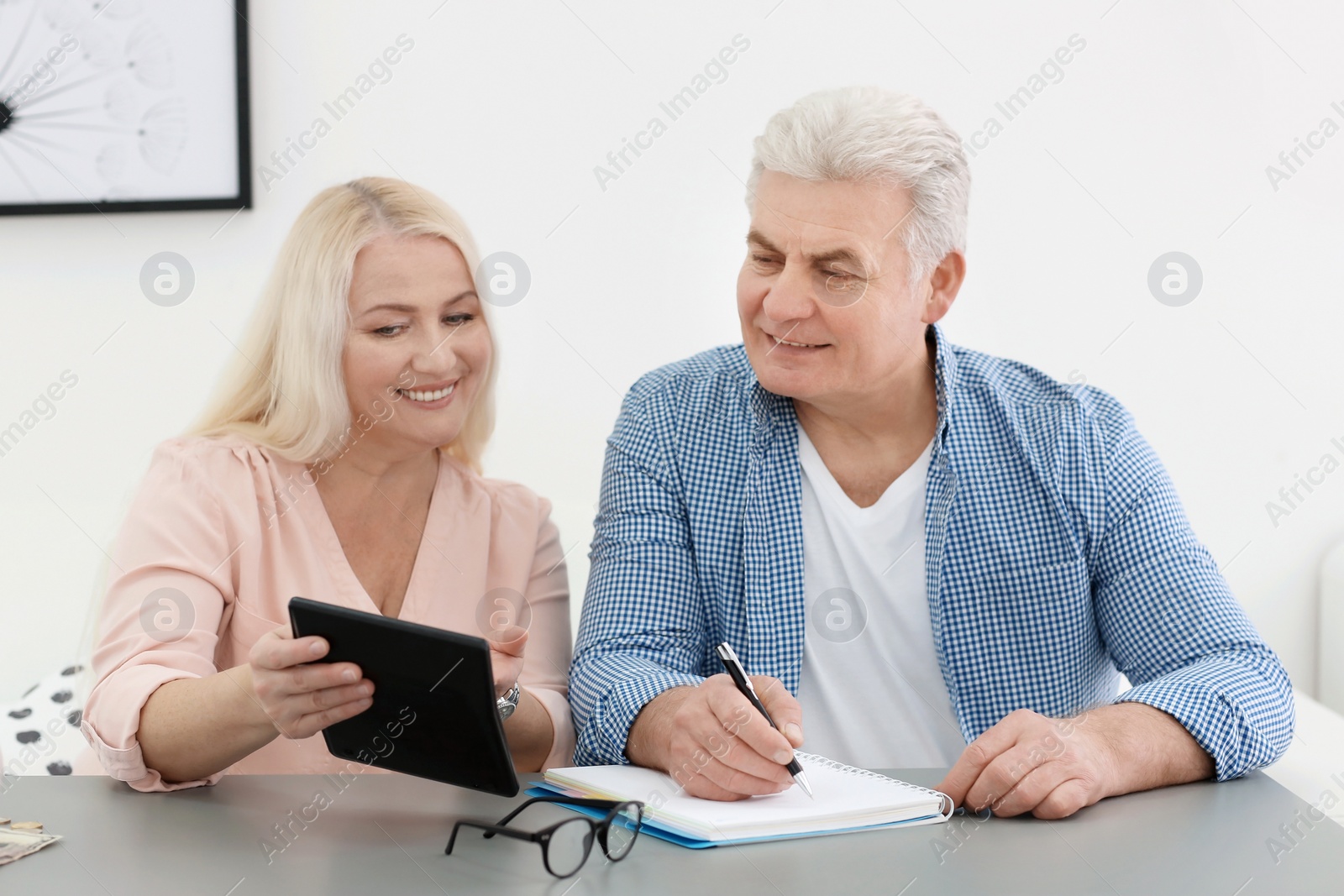 Photo of Mature couple thinking over pension payment at home