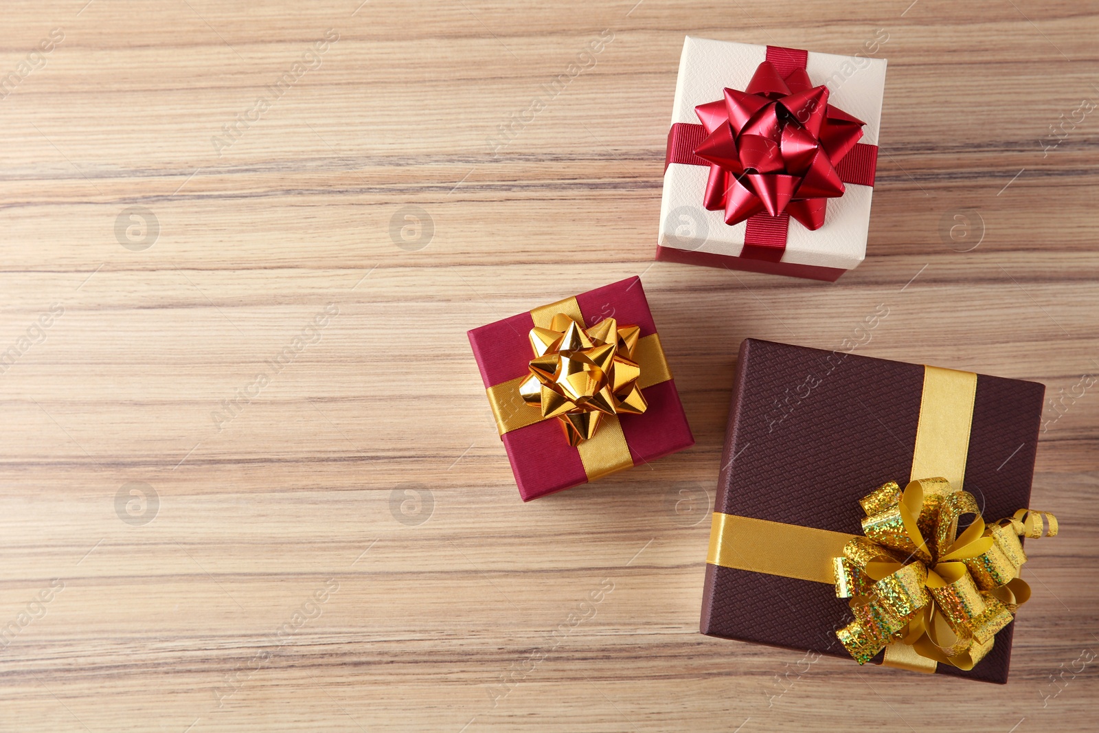 Photo of Flat lay composition with beautiful gift boxes on wooden table. Space for text