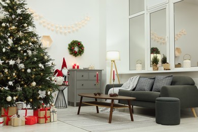 Beautiful Christmas tree, gift boxes and decor in living room. Interior design